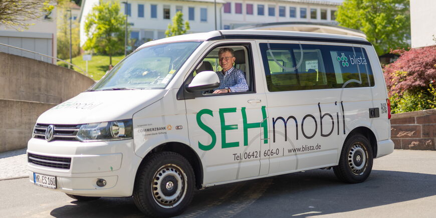 Der Seniorenberater sitzt im Sehmobil auf dem blistaCampus.