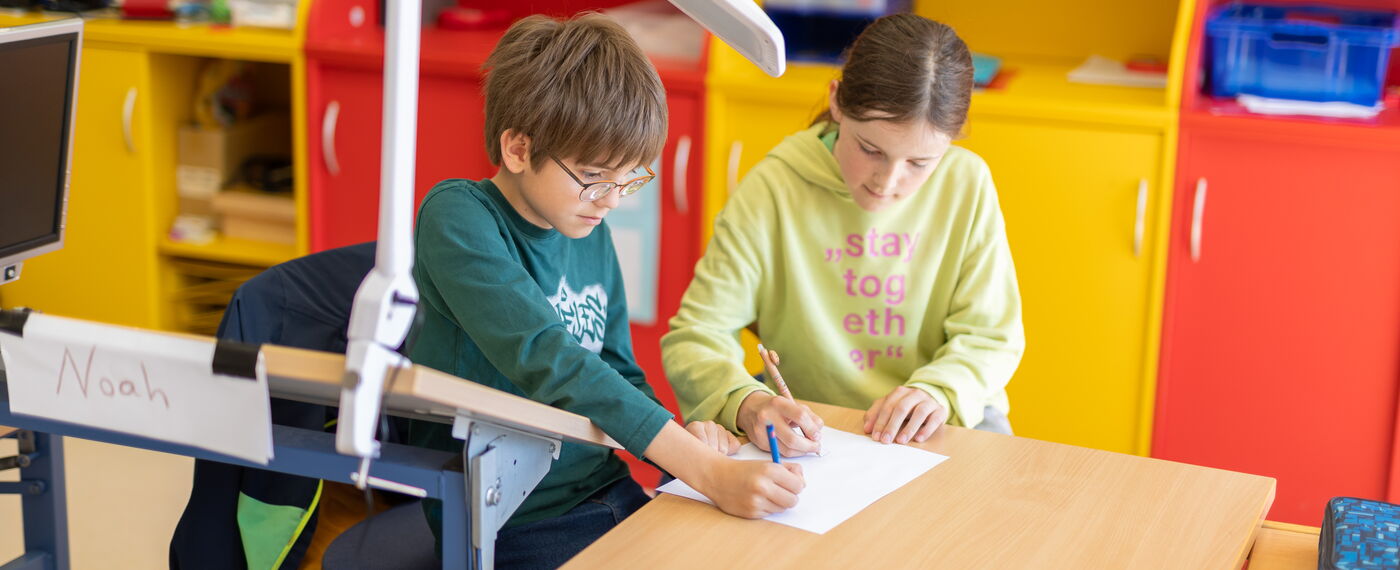 Zwei Schüler*innen arbeiten gemeinsam an einem Arbeitsblatt.