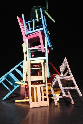 Das Foto zeigt bunte hoch gestapelte Stühle