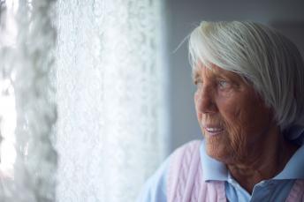 Eine ältere Dame steht am Fenster