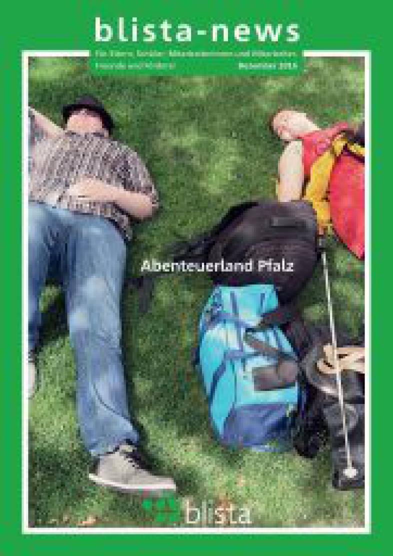 Eine Schülerin und ein Schüler liegen im Gras unter einem Baum und dösen vor sich hin. Zwischen ihnen sind verschiedene Gepäckstücke und ein Langstock.