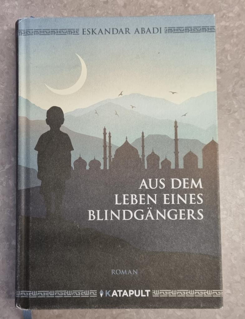 Das Buchcover von Eskandar Abadi - "Aus dem Leben eines Blindgängers" zeigt als Grafik die schwarze Silhouette eines Jungen, der bei Neumond vor einer orientalischen Stadtskyline mit Minaretten und Kuppeldächern steht. 
