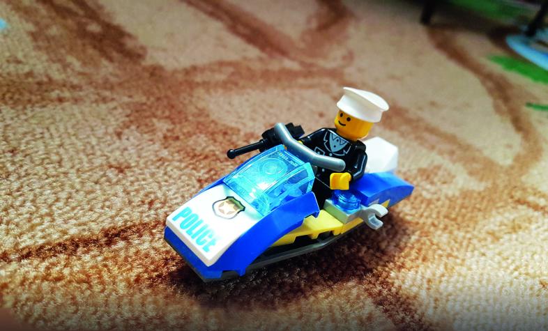 Legofigur mit Polizeiauto