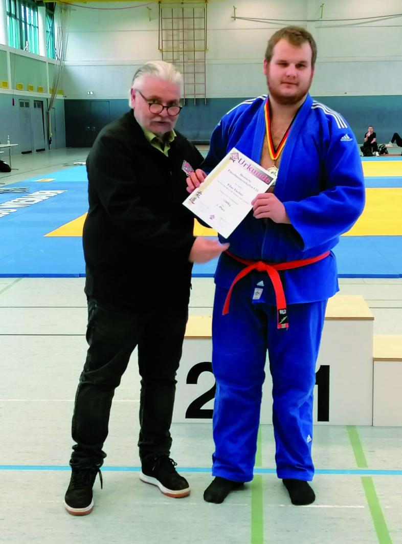 Judoverbandspräsident Sven Deeg überreicht Elias Tischler die Silbermedaille als hessischer Vizemeister.