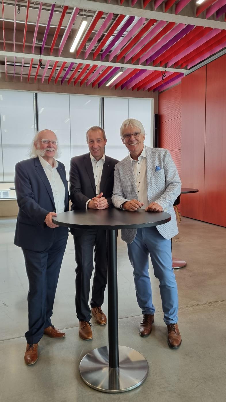 Jürgen Hertlein, Patrick Temmesfeld und Claus Duncker stehen festlich gekleidet an einem Stehtisch.