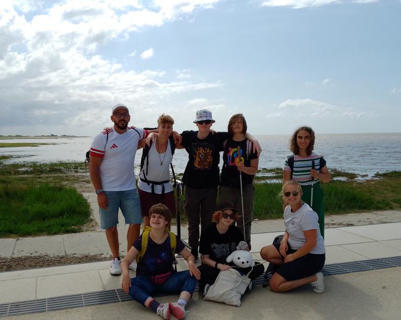 Gruppenfoto der WG am Weinberg an einer Promenade, im Hintergrund die Nordsee.