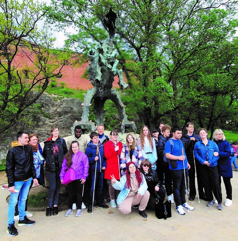 Die polnisch-deutsche Schüler*innen-Gruppe vor dem großen bronzenen Drachen ("Smok"), der unterhalb der Wawelburg regelmäßig Feuer speit.