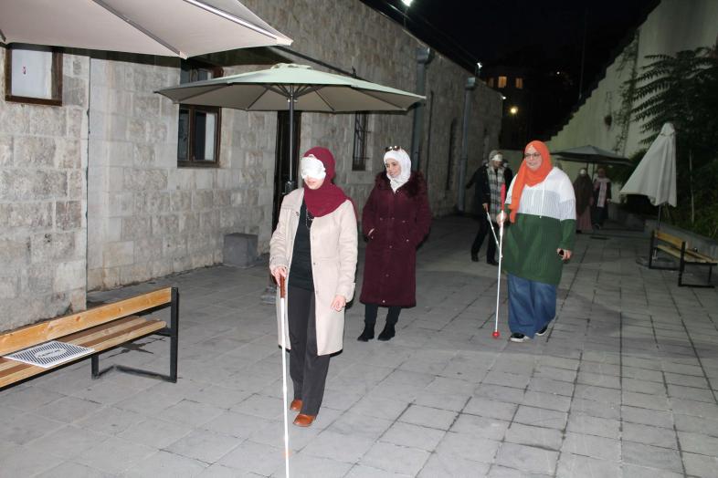 1.	Vier Mitarbeiterinnen des Vision-Rehabilitation-Center (teils unter der Augenbinde) erkunden bei Nacht mit Langstock das Außengelände der German-Jordanian-University.