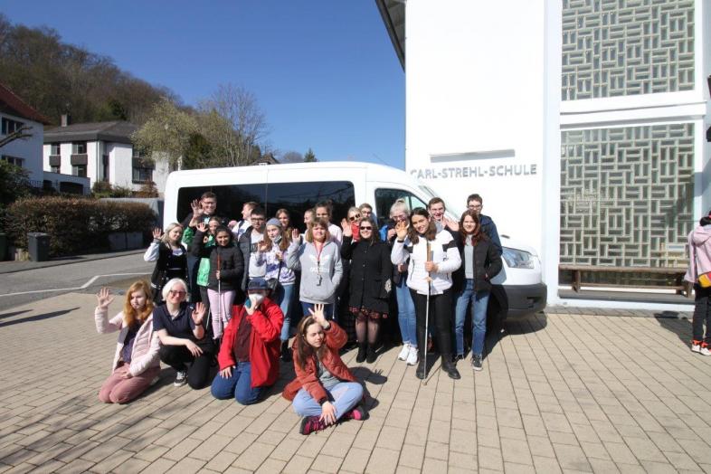 28 große und kleineren Spender*innen stehen vor einem Kleinbus der Carl-Strehl-Schule