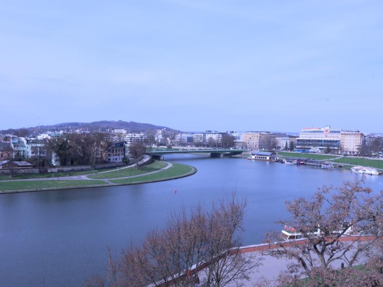 Das Bild zeigt eine winterliche Flusslandschaft in Krakau, Polen, mit Blick vom Wawel-Hügel auf die Weichsel.