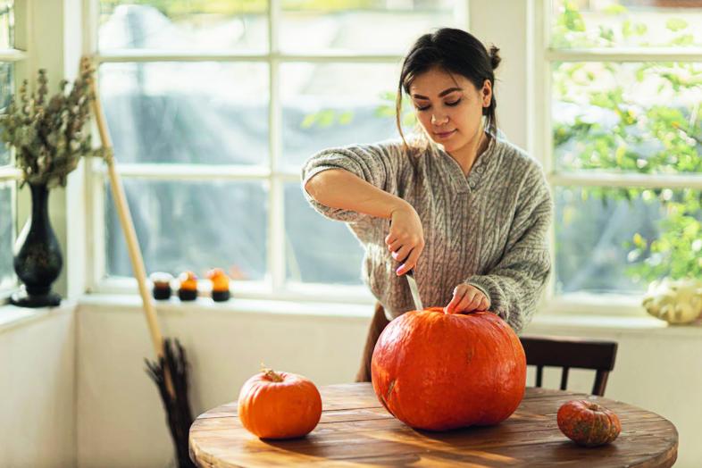 Eine Person höhlt einen Kürbis aus.