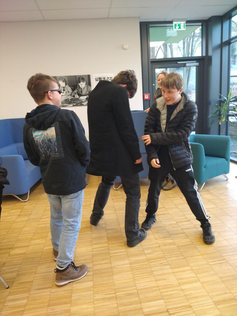 Im Workshop „Unschlagbar auftreten" machen drei Schüler eine Übung zum Thema selbstbewusstes Auftreten. 