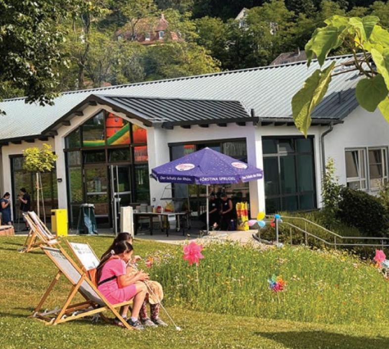 . Der blistaCampus beim Sommerfest mit Sonnenschirmen und Liegestühlen.