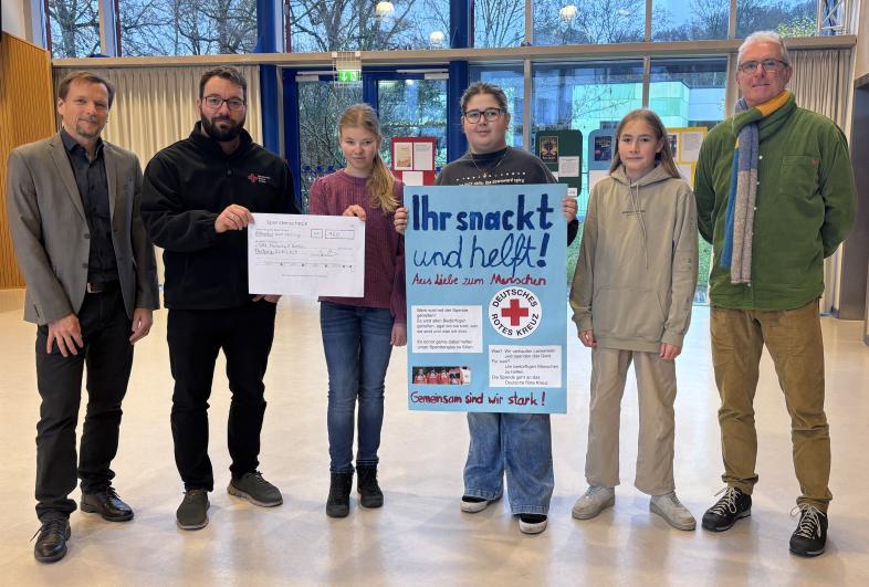 Die Ethikgruppe, ihr Lehrer Gerrit Arnold und Schulleiter Peter Audretsch bei der Übergabe des Schecks an Johannes Klotz vom DRK.