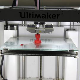 3-D-Drucker in Aktion: Man kann bereits eine kleine rote Figur erkennen