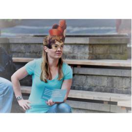 Eine maskierte Hürdenläuferin hält eine der Botschaften in den Händen