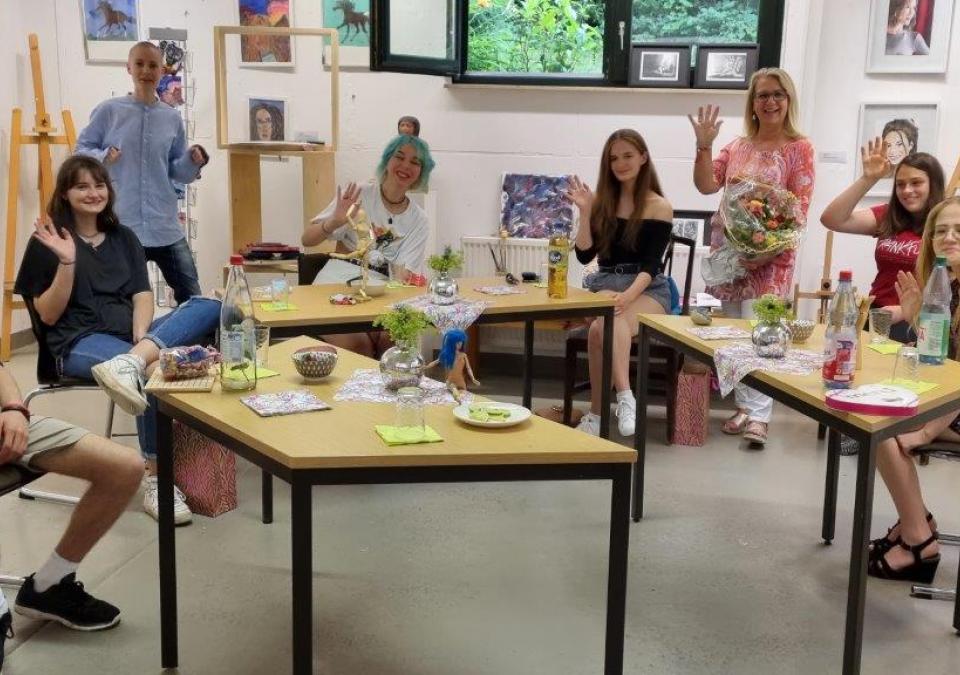 Bild 4 von 6: Schüler*innen sitzen vergnügt im Malatelier