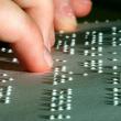 Ein Finger ertastet einen Braille-Text