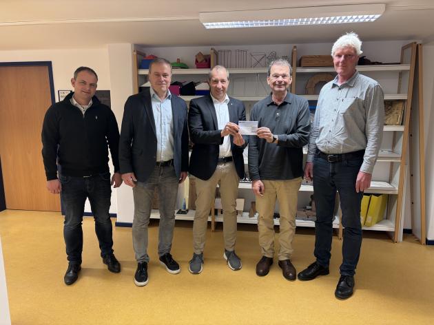 M. Kubeja und P. Temmesfeld nehmen im Medienzentrum den Scheck von Herrn Busch, Herrn Braun und Herrn Lotz der Firma Sundo entgegen.